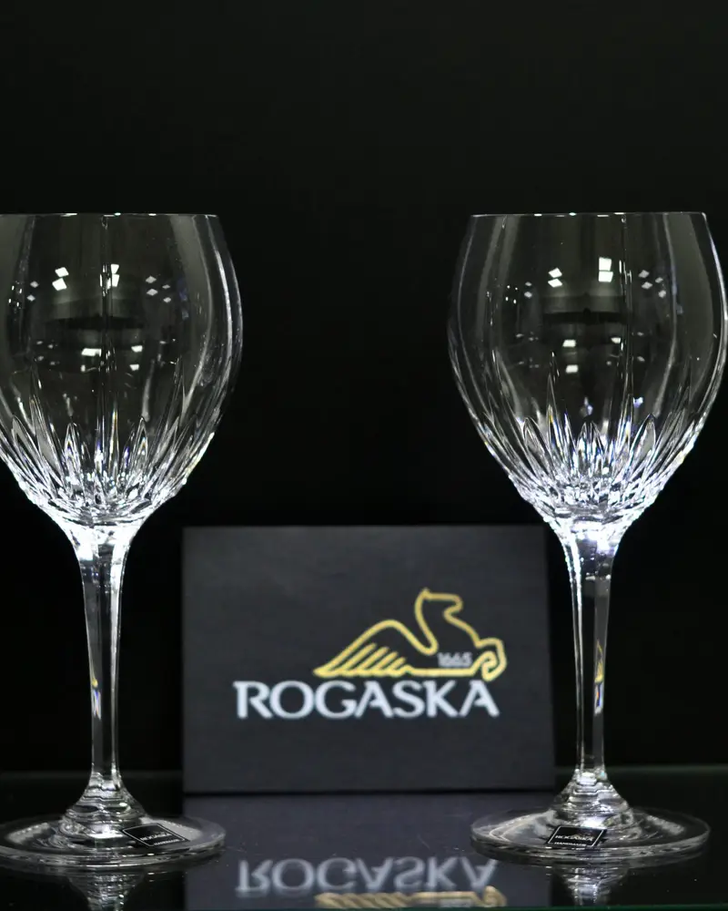 Dvije kristalne čaše za vino ispred kutije Rogaška